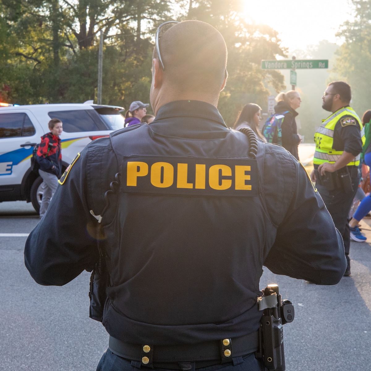  A police officer standing watch as students walk to school