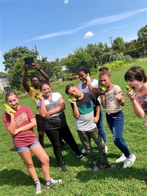 Gardent club members being silly with harvested veggies. 