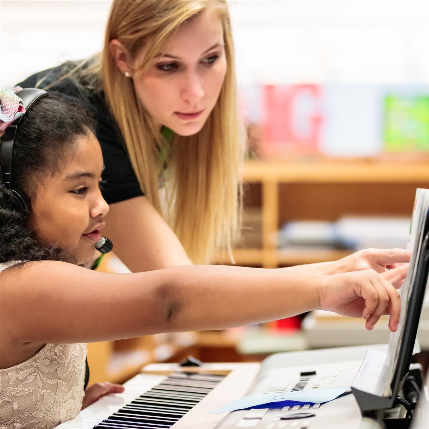  student and teacher at computer