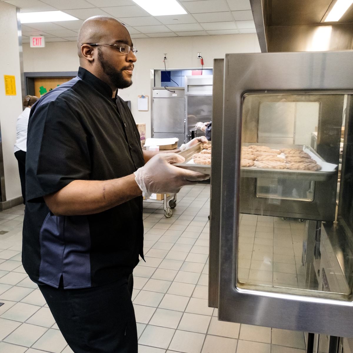  A CNS worker puts a tray of burgers into the oven