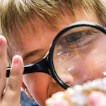 student looking in a magnifying glass