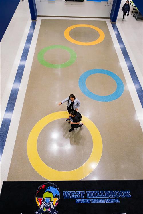 A teacher talks with a student in the lobby of West Millbrook Magnet Middle School.