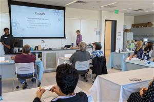 Research methods classroom with students presenting the causes of a disease