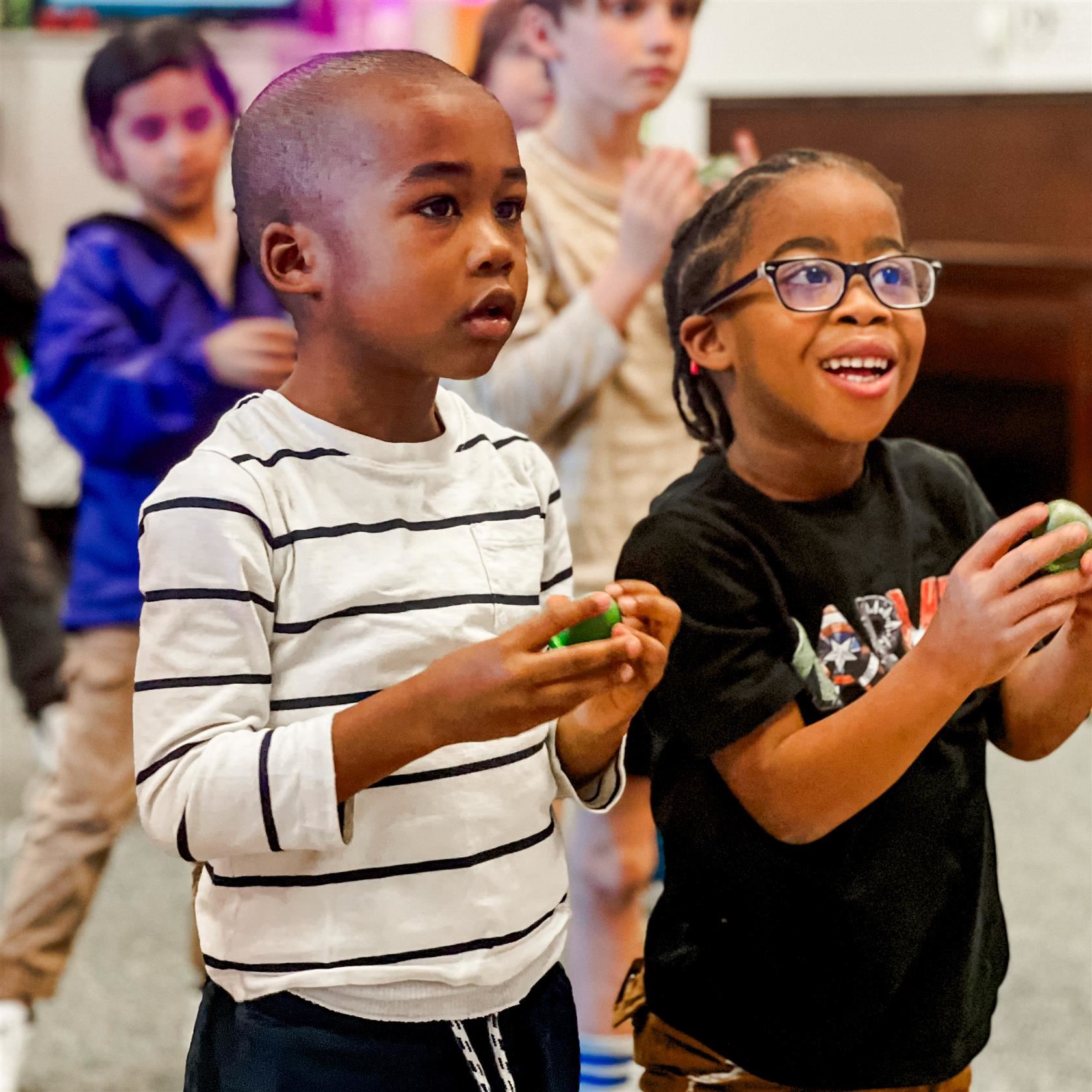  Two students smile while playing an educational game