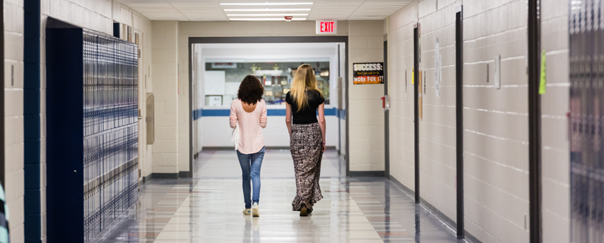 Students walking down school hallway. 