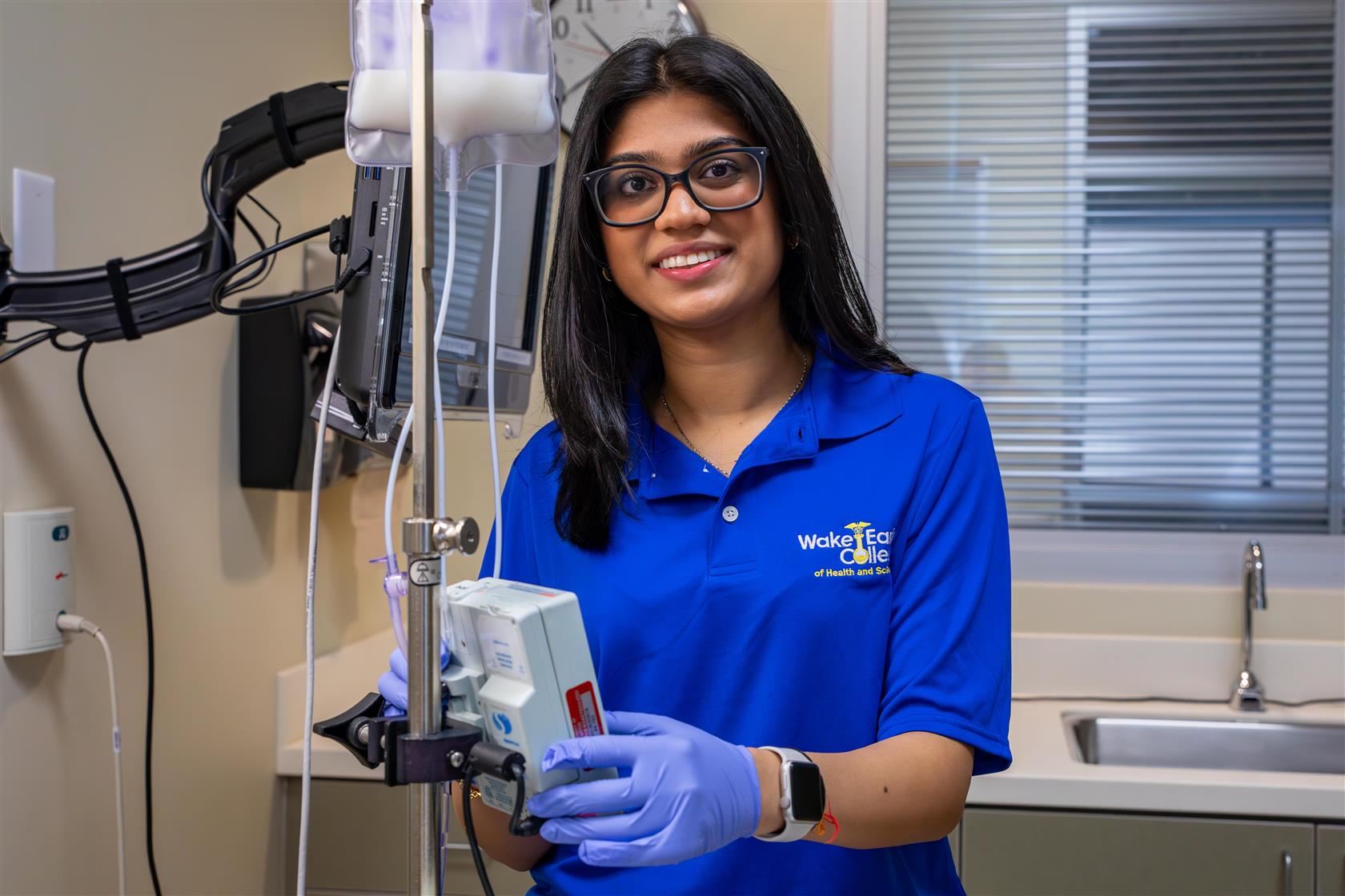 Anya smiles while adjusting medical equipment