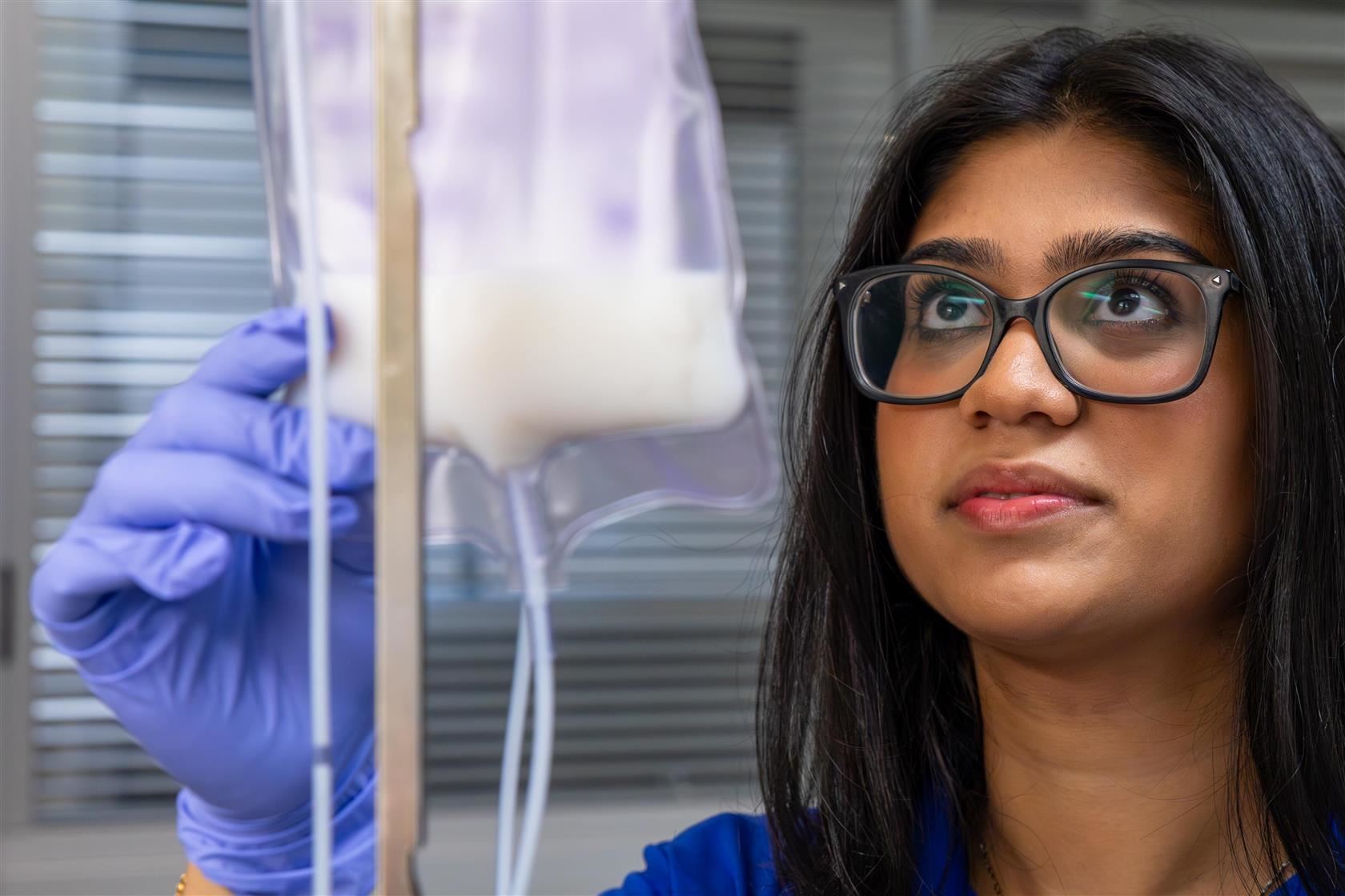 Anya examines an IV bag