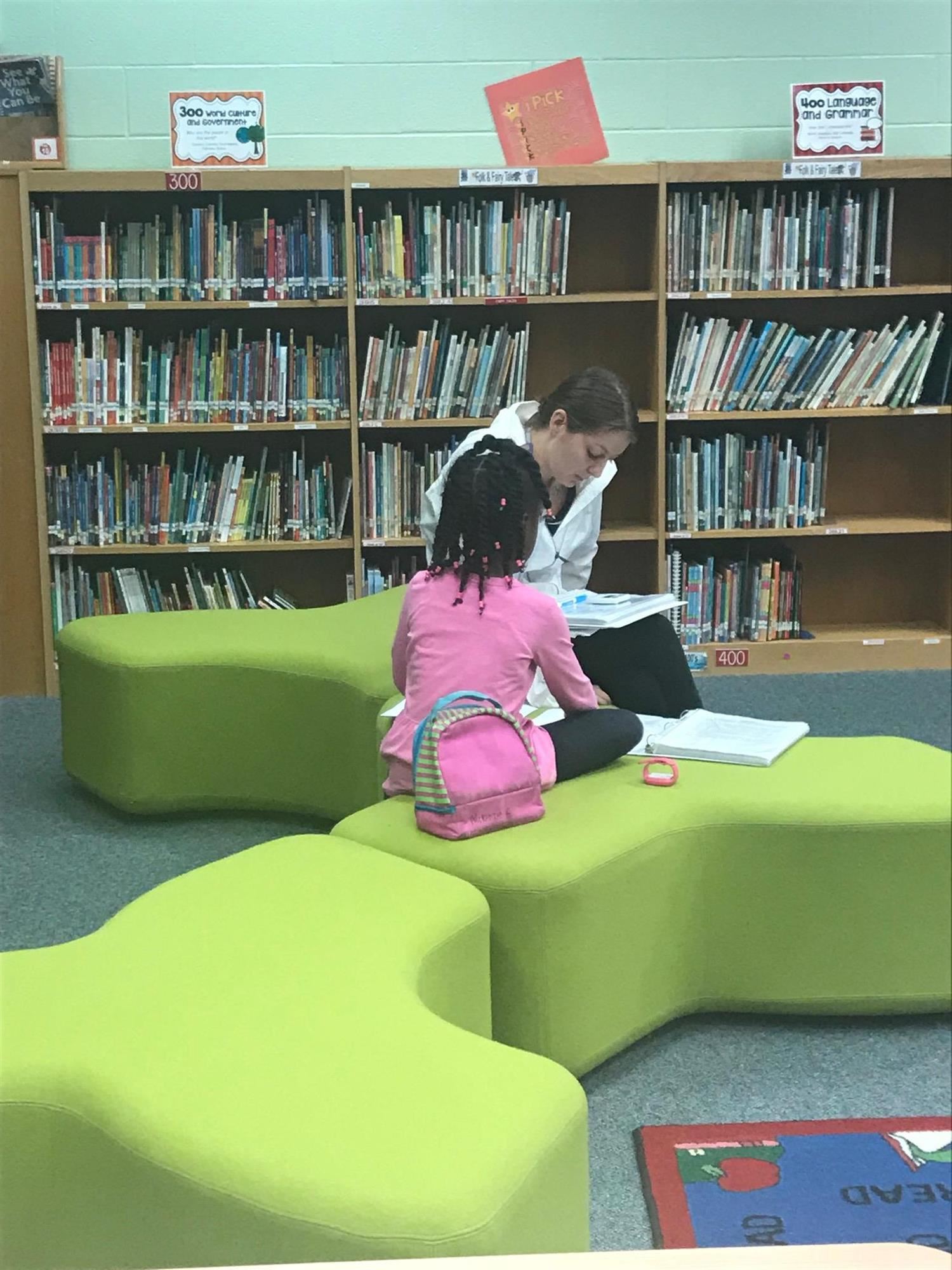 student and teacher reading in the media center