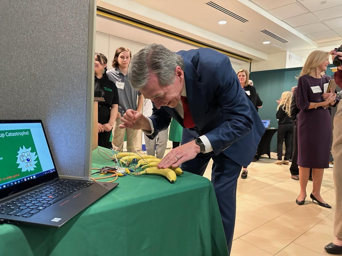 Governor Cooper trying out the ATAM bananas piano. 