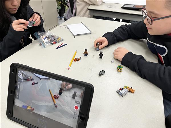 Students use Lego figures as characters and are recording figures with an Ipad to be made into a Stop Motion Video