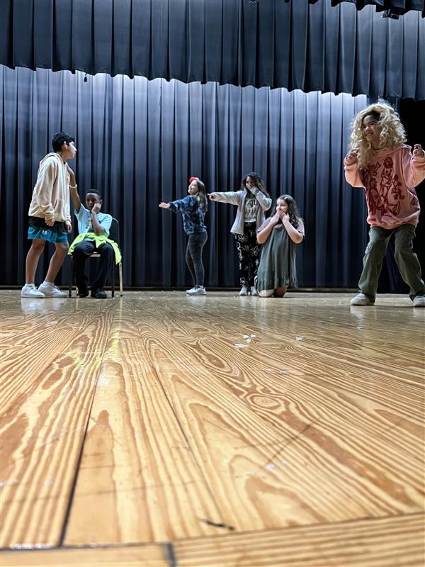 Students on stage frozen in poses